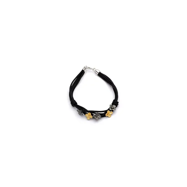 svart armbånd i lær med blomsteranheng i forgylt og rhodinert sølv